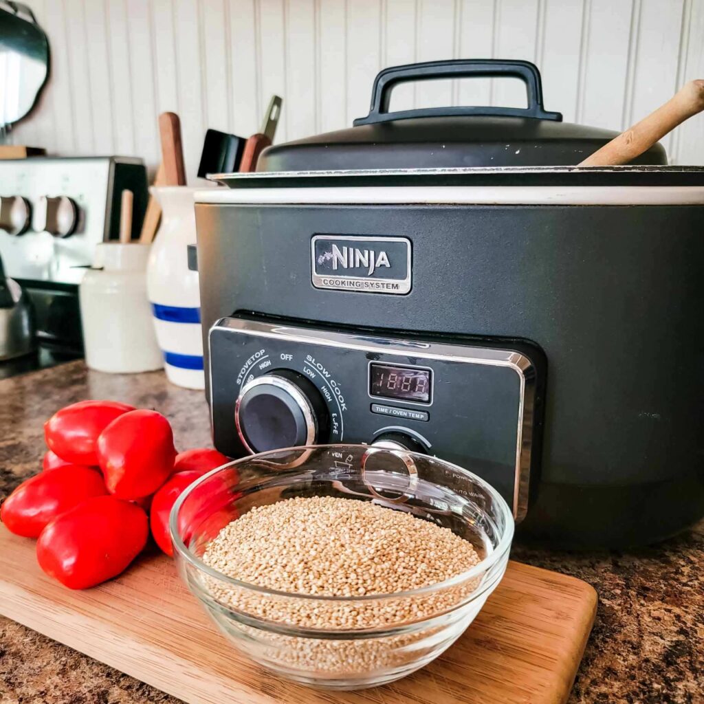 Ninja crockpot, grains, and red pepper sit on kitchen counter. 