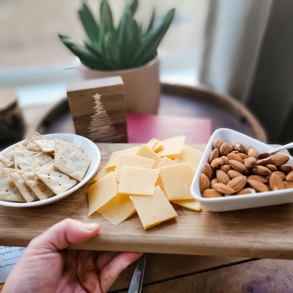 Cheese and nuts displayed on a charcuterie board. 