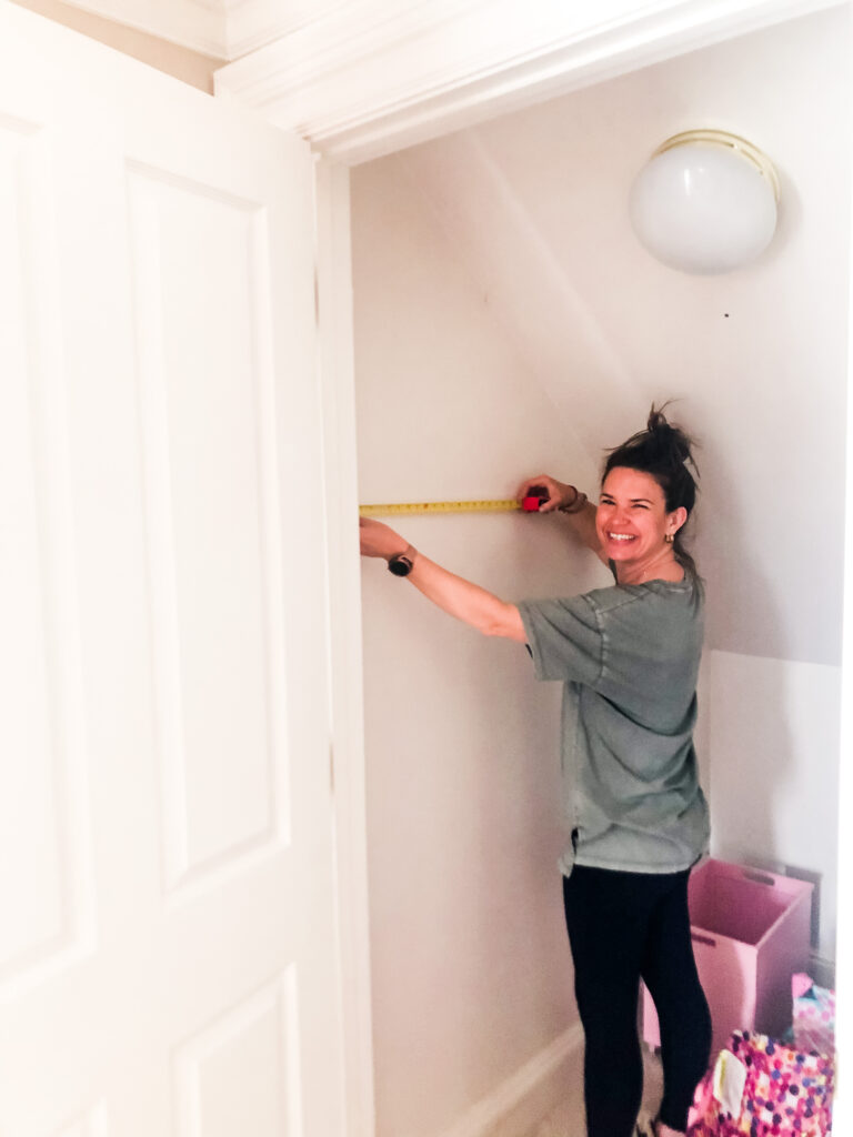 woman measures closet, tape measure, attic space, professional organizer