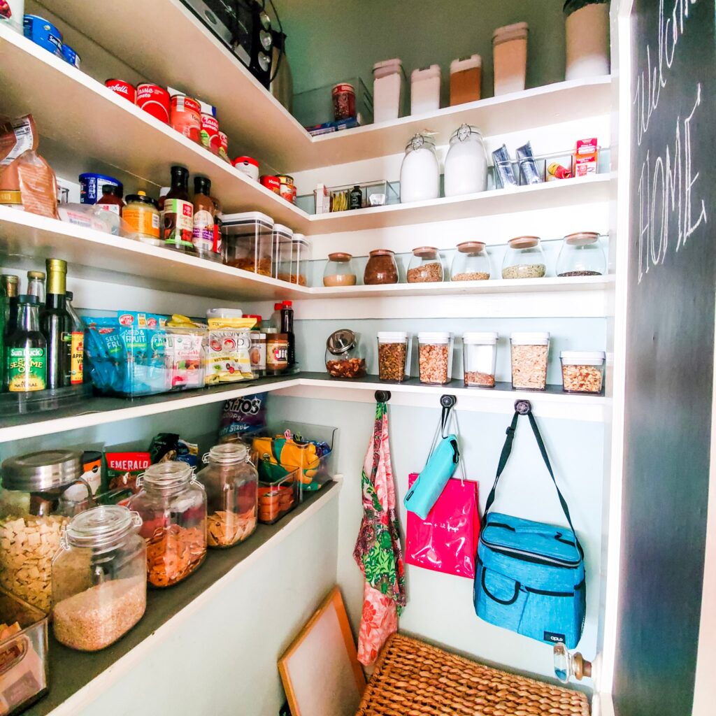 organized pantry with glass jars, bins, lazy susans, and lunchboxes. 